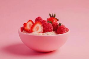 Pink bowl with strawberries, raspberries, and yogurt on pink background photo