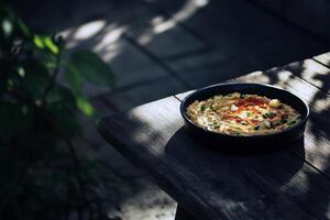 Mediterranean hummus plate on rustic wooden table in sunlit garden photo