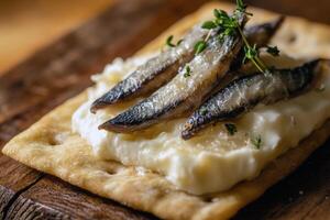 Gourmet crackers with creamy cheese and sardines garnished with fresh thyme photo