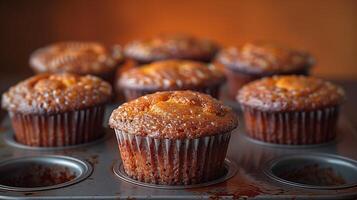 Freshly baked golden muffins in a tray with a warm and inviting glow photo