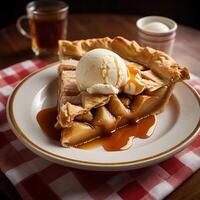 A slice of pie on a plate with ice cream and caramel sauce photo