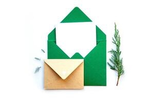 Crafty green envelope and letter with sprigs of evergreen on a white background for holiday greetings and seasonal projects photo