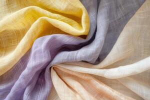 Linen fabric elegantly folds to reveal a soft palette of yellow, lavender, gray, and cream, showcasing its texture and lightness photo