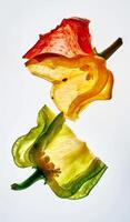 Slices of yellow, green, and red bell peppers reveal their vibrant colors and unique textures against a light background, emphasizing the fresh and healthy appeal of these vegetables photo