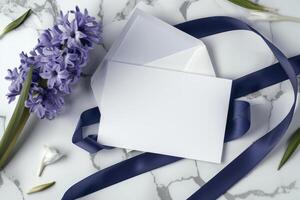 Blank wedding stationery is beautifully arranged with purple flowers and a satin ribbon, creating an elegant and romantic atmosphere for wedding planning photo