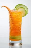 A vibrant carrot cocktail is presented in a tall glass, showcasing a colorful blend of orange and green. Fresh cucumber slices garnish the drink, adding an eye-catching detail photo