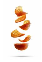 Bright orange peel segments are suspended in the air, creating a dynamic visual. The pieces exhibit rich texture and a striking color contrast, enhancing the lively feel of the scene photo