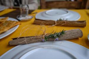 Elegant table setting featuring rustic decor with fresh herbs and handcrafted elements at a cozy dining spot photo