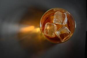 Refreshing iced tea in a clear glass on a dark surface, capturing the essence of summer relaxation photo