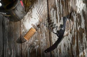 Corkscrew and cork resting on rustic wooden table beside a bottle waiting to be opened photo