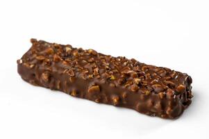 Decadent chocolate bar coated with crunchy nuts captures sweet indulgence in a simple setting photo