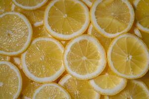 Freshly sliced lemons create a vibrant display of yellow on a sunny kitchen counter photo