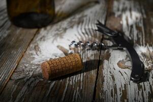 Cork and corkscrew resting on a rustic wooden surface after an evening of wine tasting photo