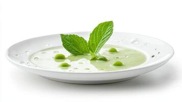 Fresh green pea soup garnished with mint leave photo