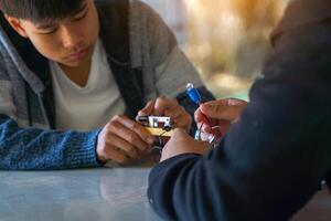 Thai student performs an outdoor science experiment on connecting a simple electrical circuit by connecting light bulbs in series and observing their brightness. photo