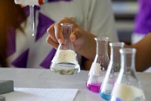 Close-up of student performing an acid-base titration experiment. Concept of chemistry lab, science, experiment, skills, learning. photo