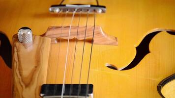 Detail of frets, string, body, mouth and bridge of typical classic spanish guitar rotating in black background video