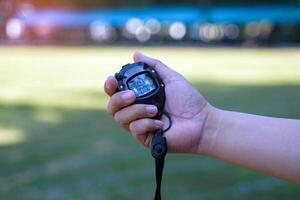 Coach holds a stopwatch to check the runners' speed statistics during practice. photo