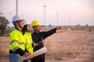 A team of maintenance engineers is planning the maintenance of wind turbines in a wind farm photo