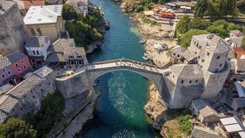 Top view of famous Mostar bridge. Aerial landscape view of tourist attraction with city background in summer photo