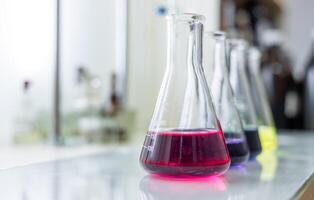 A laboratory with several colorful liquid in beakers photo