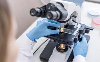 A person in a lab coat is looking at a microscope photo