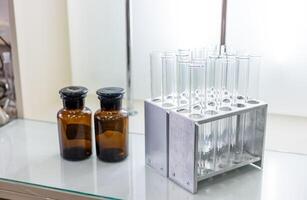 A glass table with a glass shelf and a metal stand photo