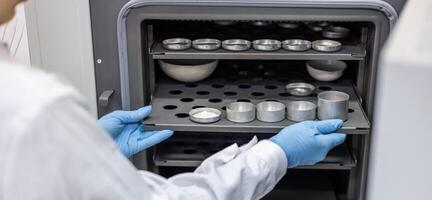 A person in a lab coat is holding a tray of cups photo