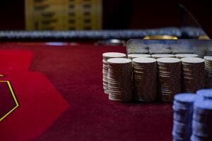 A pile of coins on a table with a poker chip photo