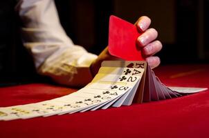 A person holding a red card in front of a stack of cards photo