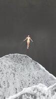 Tourist relaxing on volcanic black sand beach with ocean waves in Bali Indonesia video