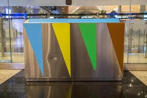 Close-up of green, blue, and red trash cans for separate dumping of glass, paper, and other trash in the store. Concept of proper waste disposal. photo