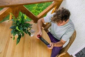 Man watching a game console in a terrace in summer. Technology and game addiction concept photo