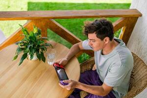 Man watching a game console in a terrace in summer. Technology and game addiction concept photo