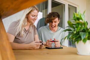 Joyful man and woman playing games on terrace. Technology and game console concept photo