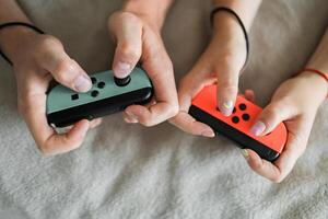 Woman and man playing on the game console. Holding hands gamepad, game controller photo