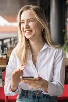 Restaurant and smartphone. Relaxed blond woman typing and scroll or check email and contact social media app or social network user. Happy smile and young gen z girl with mobile tech post to online photo