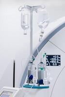Contrast agent and CT scanner before diagnostics in the room. The concept of using modern technologies for accurate vascular examinations and disease diagnostics. Vertical shot photo