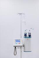 A drip with saline solution in the operating room. Syringe pump with blurred medical equipment background. Intravenous fluid infusion for a patient with blood loss during surgery. Vertical shot photo