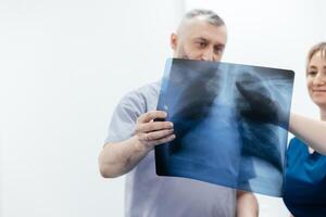 A doctor and specialist in an MRI or CT room analyze images, discussing the examination results. The concept of effective teamwork for accurate diagnostics and optimal treatment. photo