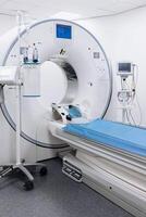 A high-angle shot of a CT scan machine room, showing the advanced medical imaging equipment and the clean, organized environment of the room. Vertical shot, advertising photo