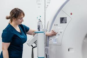 A medical nurse, doctor push buttons of a modern MRI scanner while attending to a patient in a medical facility. The scene highlights advanced technology and healthcare support for diagnostic imaging photo