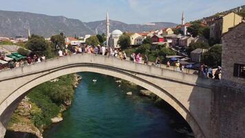Tourists on the famous old arch bridge in Mostar. Close-up view of the summer tourist attraction of the famous bridge symbol of the city of Bsoania video
