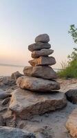 A stack of rocks on the beach at sunset photo
