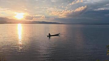 Sunset on the lake with a boat in the foreground video