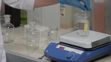 Scientist Conducting Lab Experiment with Beaker and Heating Plate video