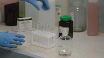 Scientist working with test tubes in laboratory, bottle labeled acetone video