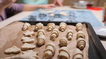 Small croissants and cookies waiting to be baked on a baking sheet video