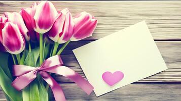 Greeting card of pink tulip bouquet with ribbon and heart card on wooden table with copy space. photo