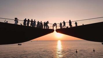 Sunset gathering on a bridge with people enjoying the view over the water video